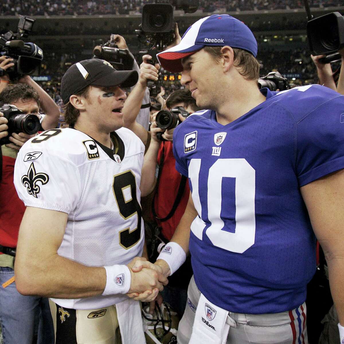 Saints quarterback Drew Brees, left, and Giants quarterback Eli Manning shake hands.