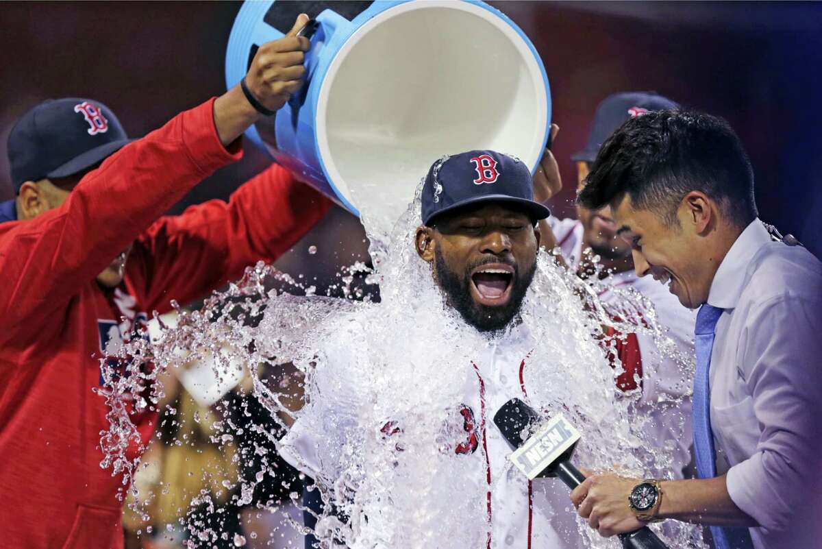 Boston Red Sox's Jackie Bradley Jr. is doused with a bucket of ice water by teammates after a 13-3 win against the Oakland Athletics at Fenway Park in Boston, Wednesday, May 11, 2016. Bradley had two home runs and six RBI's in the game. At right is baseball sideline reporter Gary Striewski. (AP Photo/Charles Krupa)