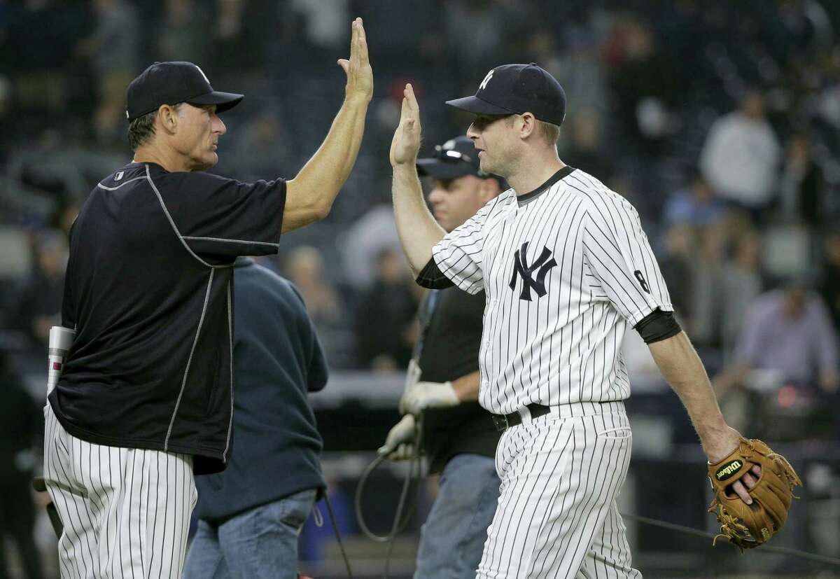 New York Yankees third baseman Chase Headley, right, high-fives hitting coach Alan Cockrell after the Yankees defeated the Kansas City Royals 7-3 Thursday in New York.