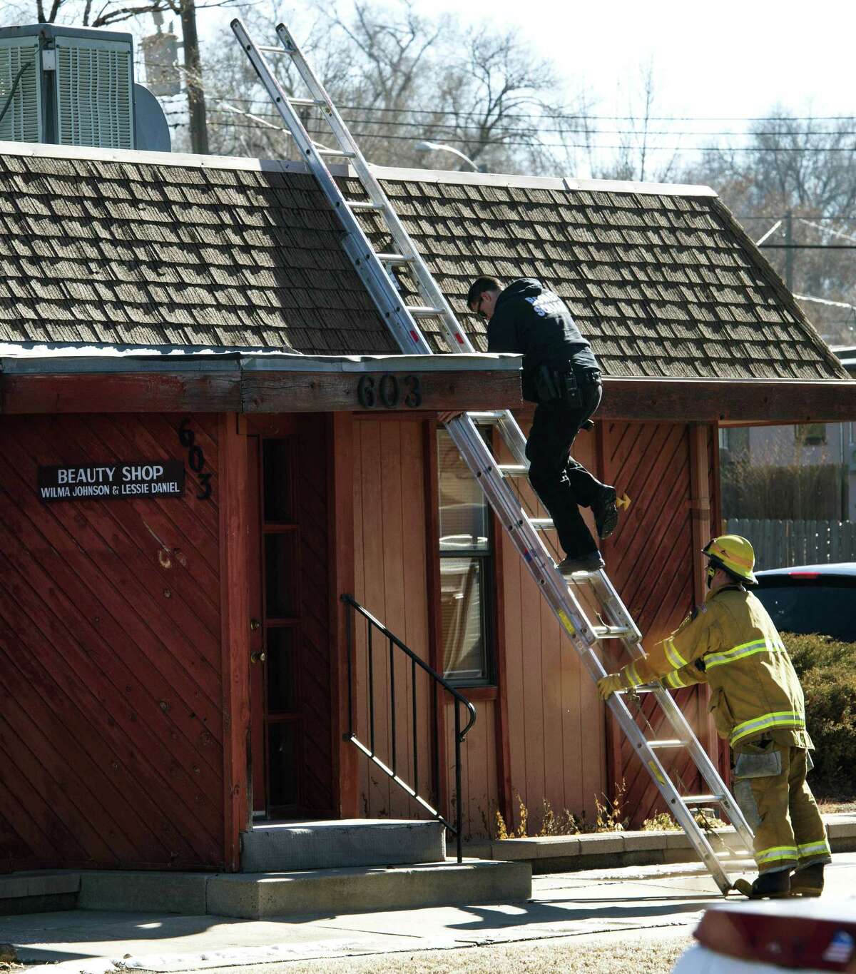 A bomb squad member comes down from the roof as Colorado Springs police officers investigate the scene of an explosion Tuesday, Jan. 6, 2015, at Mr. G’s Hair Salon at 603 S. El Paso Street in Colorado Springs, Colo.