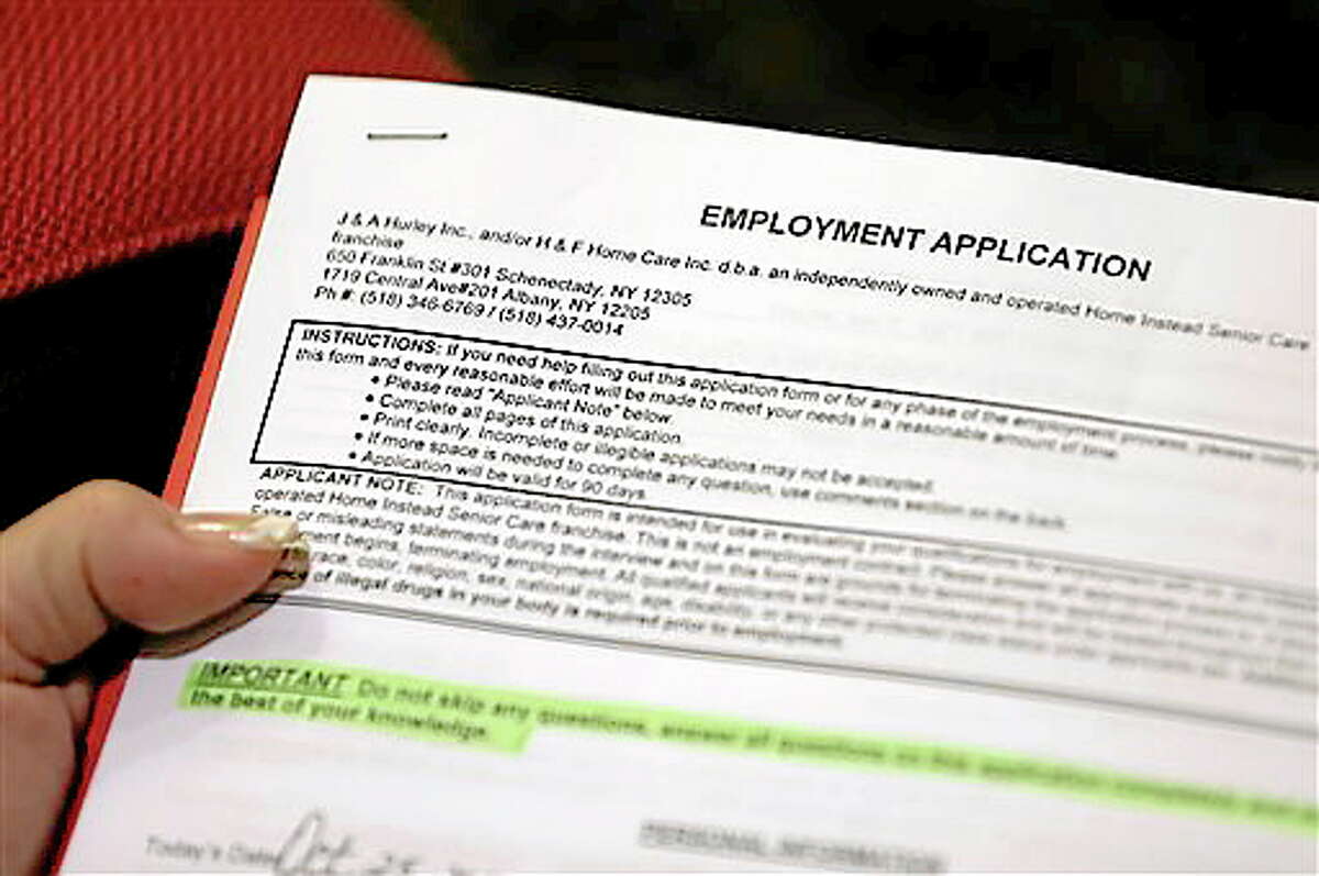 In this Thursday, Oct. 25, 2012, photo, Carmen Nazario of Albany, N.Y., fills out an employment application during a job fair at the Marriott Hotel in Colonie, N.Y. The number of Americans seeking unemployment benefits fell 23,000 to a seasonally adjusted 393,000 for the last full week of November 2012. It was the second straight drop after Superstorm Sandy had driven applications much higher earlier in November (AP Photo/Mike Groll)