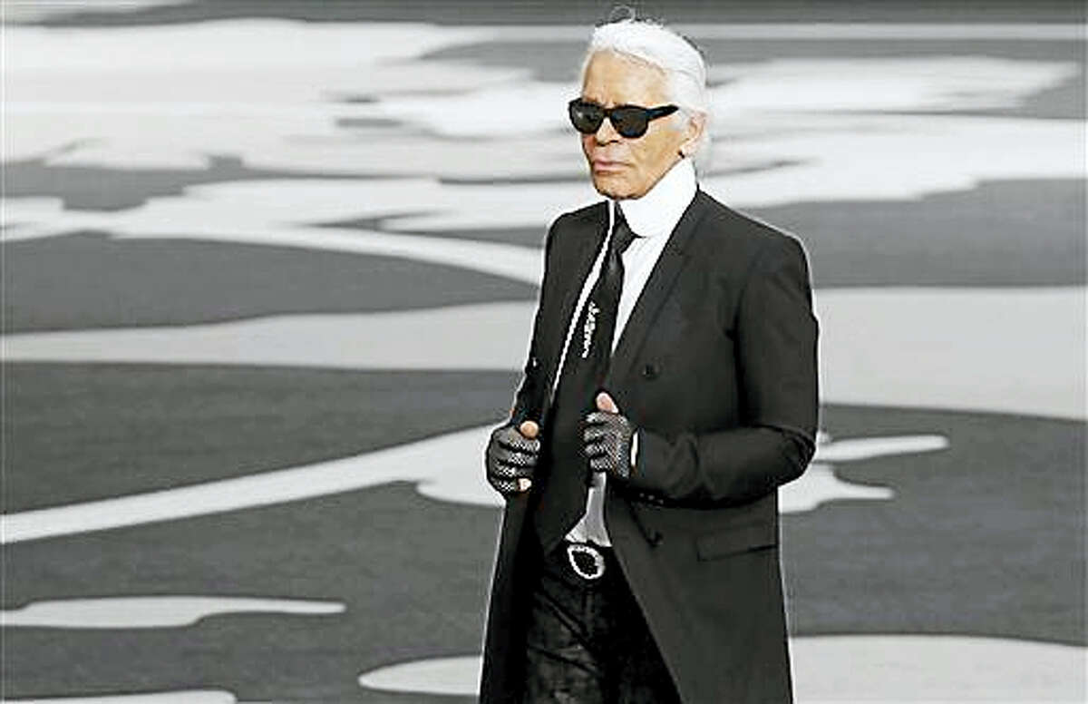 In this March, 5, 2013, file photo, German fashion designer Karl Lagerfeld acknowledges applause at the end of his Fall/Winter 2013-2014 ready to wear collection for Chanel presented in Paris. French authorities are investigating designer Karl Lagerfeld’s taxes and a French magazine says he used offshore tax havens to avoid paying millions of euros to the French government. The case is the latest involving allegations of high-end tax evasion in France, where the Finance Ministry has cracked down on fraud in recent years to ease budget strain.