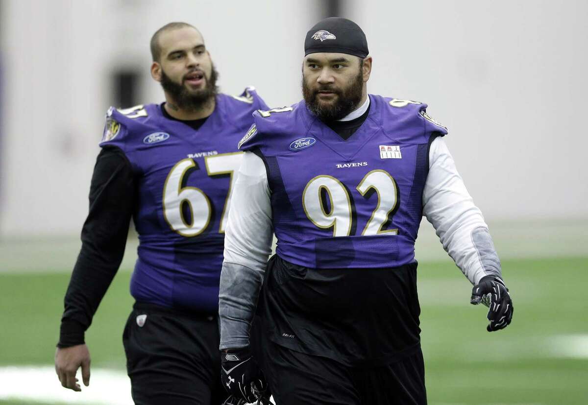 Baltimore Ravens defensive end Haloti Ngata (92) walks off the field in front of teammate Lawrence Guy after practice Wednesday in Owings Mills, Md.