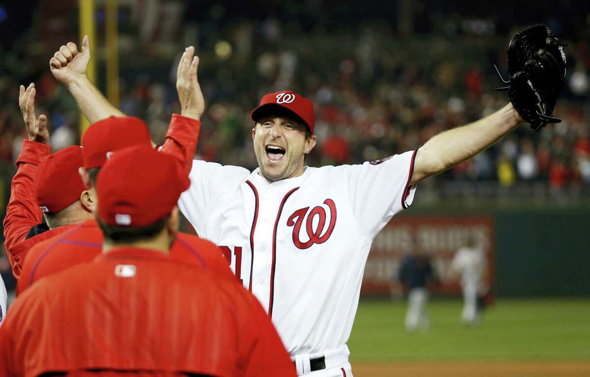 Washington Nationals starting pitcher Max Scherzer celebrates with his teammates after a baseball game against the Detroit Tigers at Nationals Park, Wednesday in Washington. Scherzer struck out 20 batters, tying the major league nine-inning record. The Nationals won 3-2.