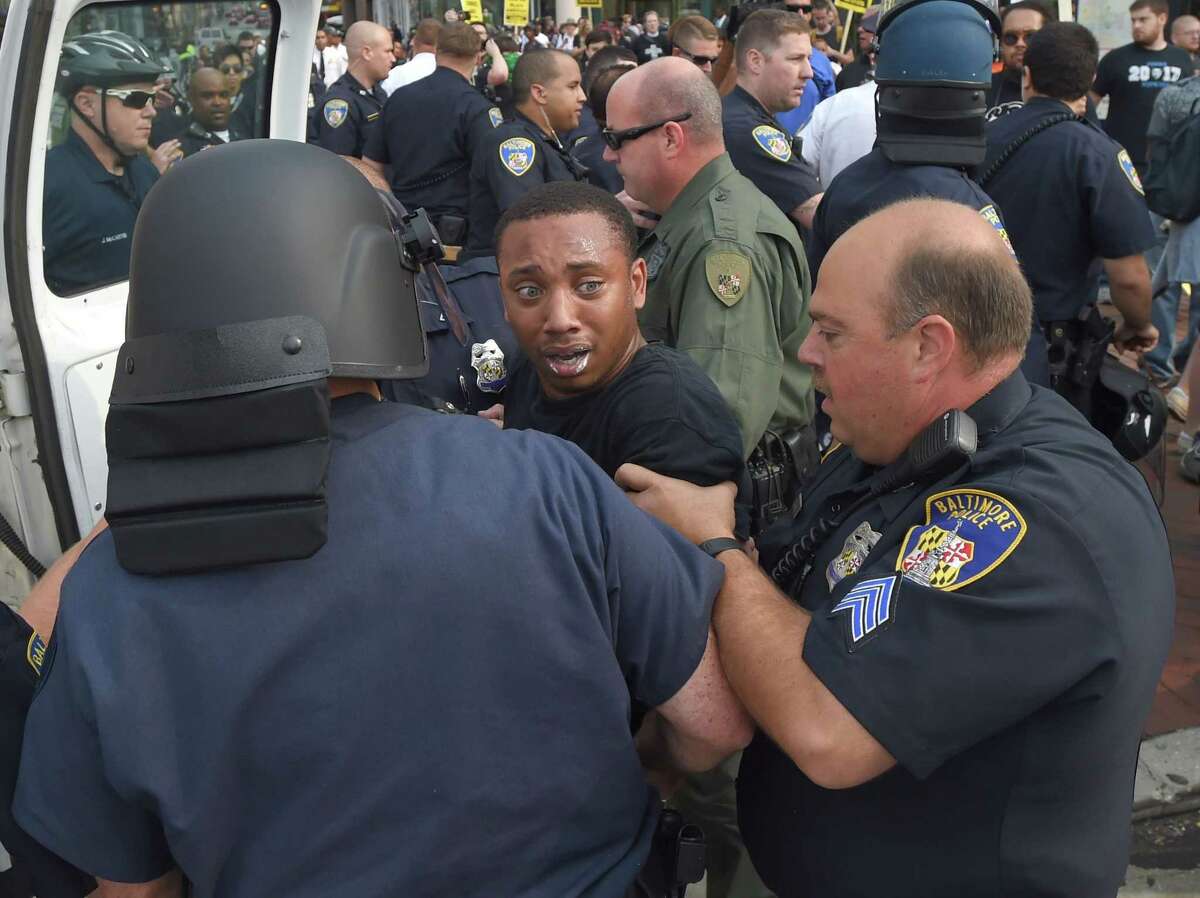 Kwame Rose is detained by police as protesters rallied outside the Baltimore courthouse during the first court hearing for six Baltimore police officers who are charged in the death of Freddie Gray, on Wednesday, Sept. 2, 2015 in Baltimore. A Baltimore judge refused to dismiss charges against the six police officers accused in the death in April of Gray, a black man who was in their custody. (Lloyd Fox/Baltimore Sun via AP) WASHINGTON EXAMINER OUT; MANDATORY CREDIT