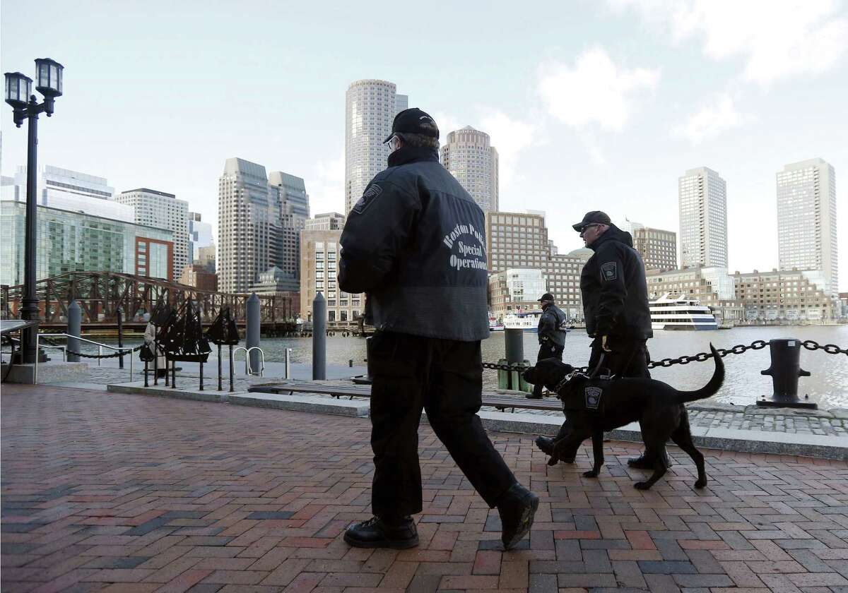 Boston police officers and a K-9 dog patrol outside the federal courthouse in Boston, Monday, Jan. 5, 2015, on the first day of jury selection in the trial of Boston Marathon bombing suspect Dzhokhar Tsarnaev. (AP Photo/Elise Amendola)