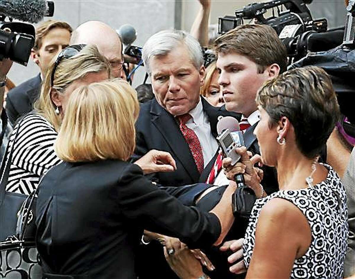FILE - In this Thursday Sept. 4, 2014 file photo, former Virginia Gov. Bob McDonnell, center, is mobbed by media, friends and family as he gets into a car with his son, Bobby, right, after being convicted on multiple counts of corruption at Federal Court in Richmond, Va. The judge in the case will sentence McDonnell Tuesday, Jan. 6, 2015, and has received over 400 letters of support for the former governor. (AP Photo/Steve Helber, File)