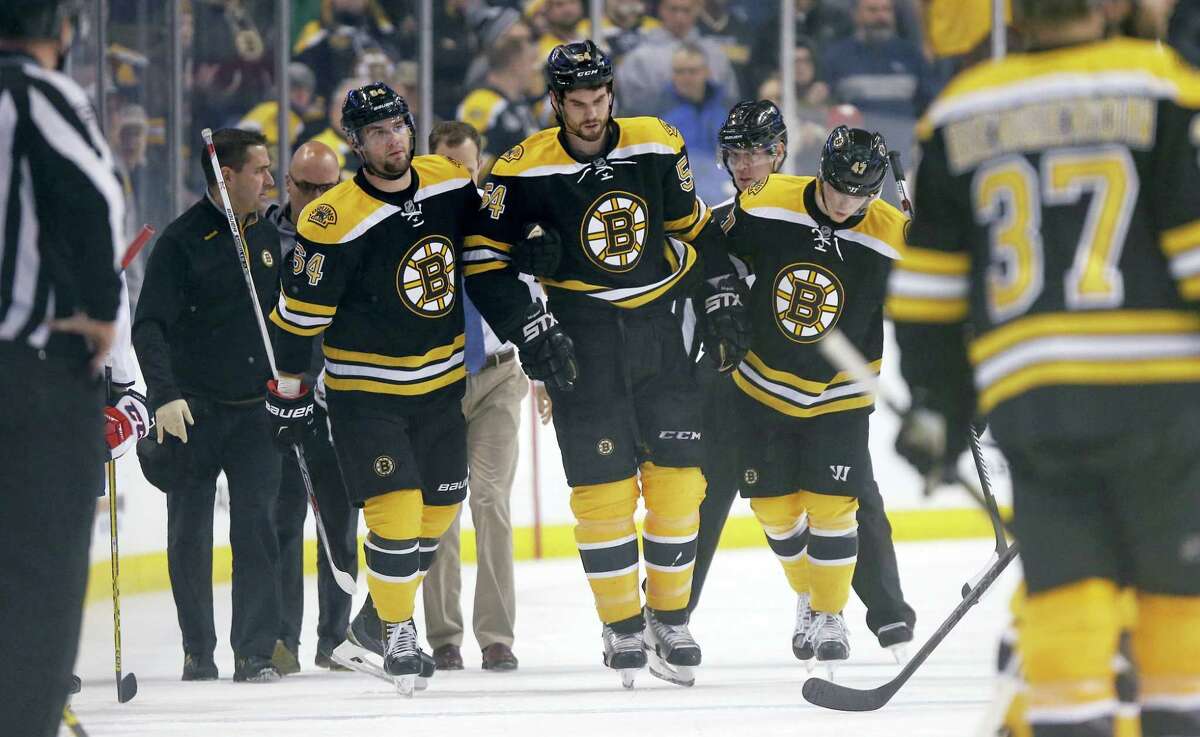 Boston Bruins' Adam McQuaid (54) leaves the ice after being injured during the second period of an NHL hockey game against the Washington Capitals in Boston, Tuesday, Jan. 5, 2016. (AP Photo/Michael Dwyer)