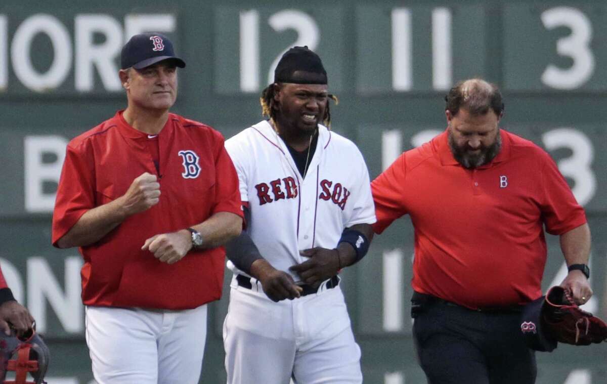 Red Sox left fielder Hanley Ramirez is helped from the field by manager John Farrell, left, and trainer Rick Jameyson during the first inning on Monday.