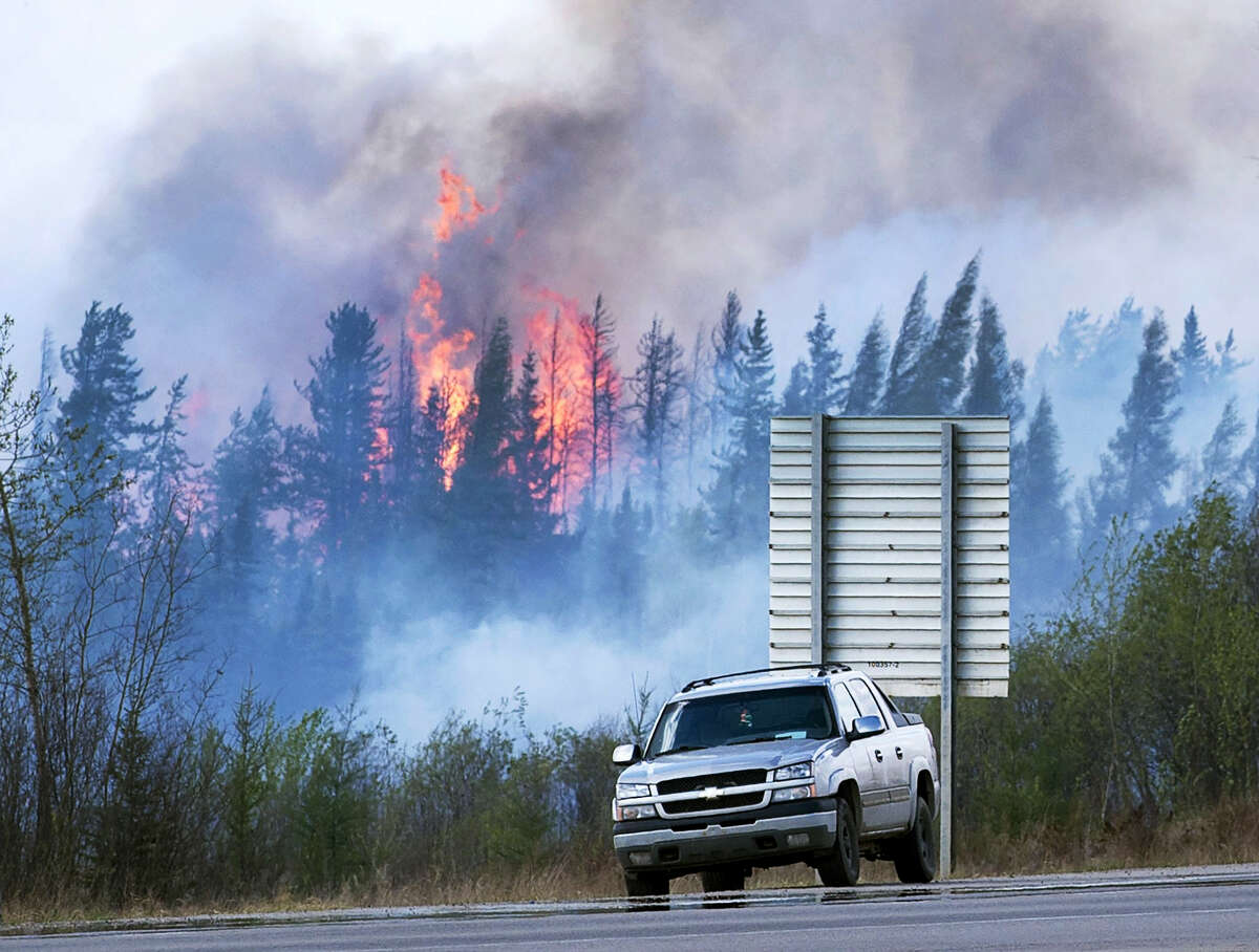 Flames flare up from hotspots along a highway to Fort McMurray, Canada, Sunday, May 8, 2016.