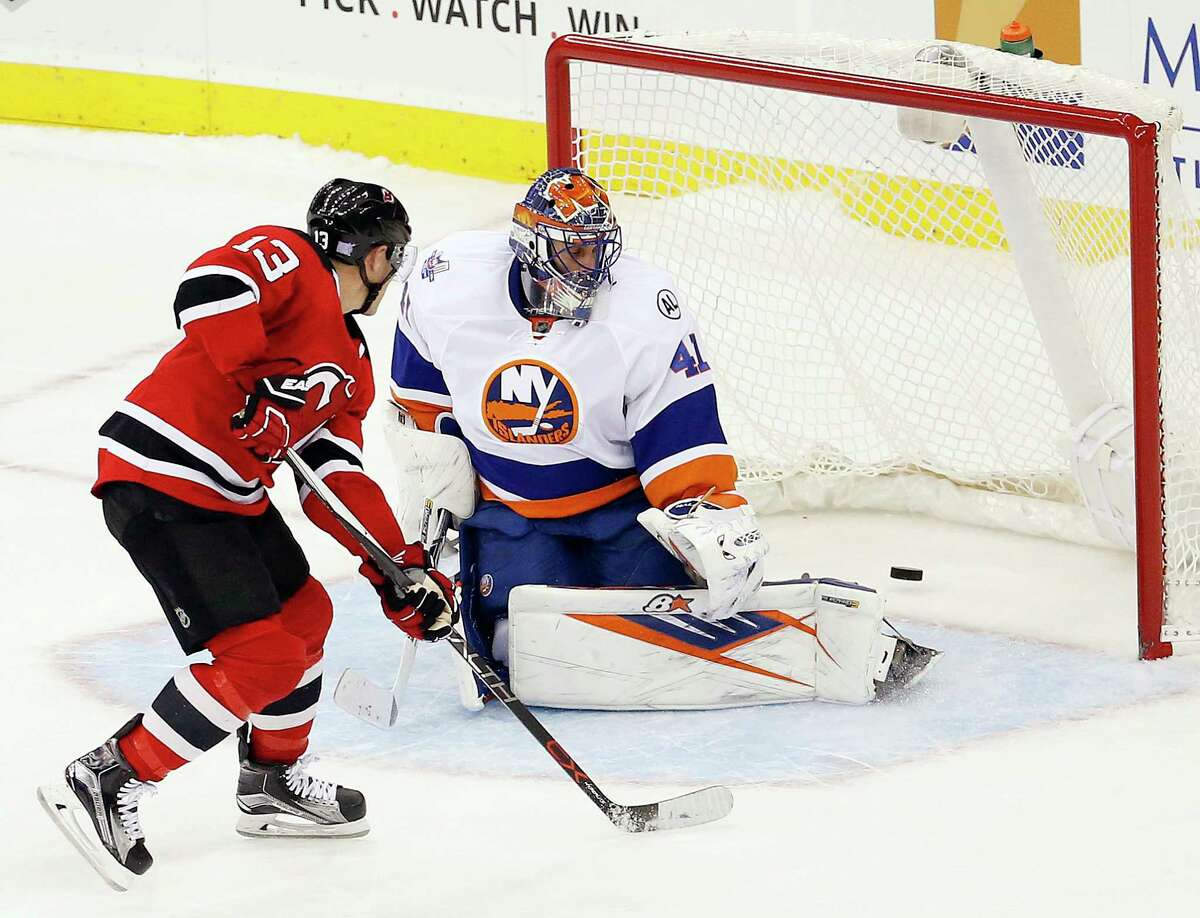 New Jersey Devils left wing Mike Cammalleri, left, scores the winning goal on the New York Islanders’ Jaroslav Halak during a shootout Saturday in Newark, N.J.
