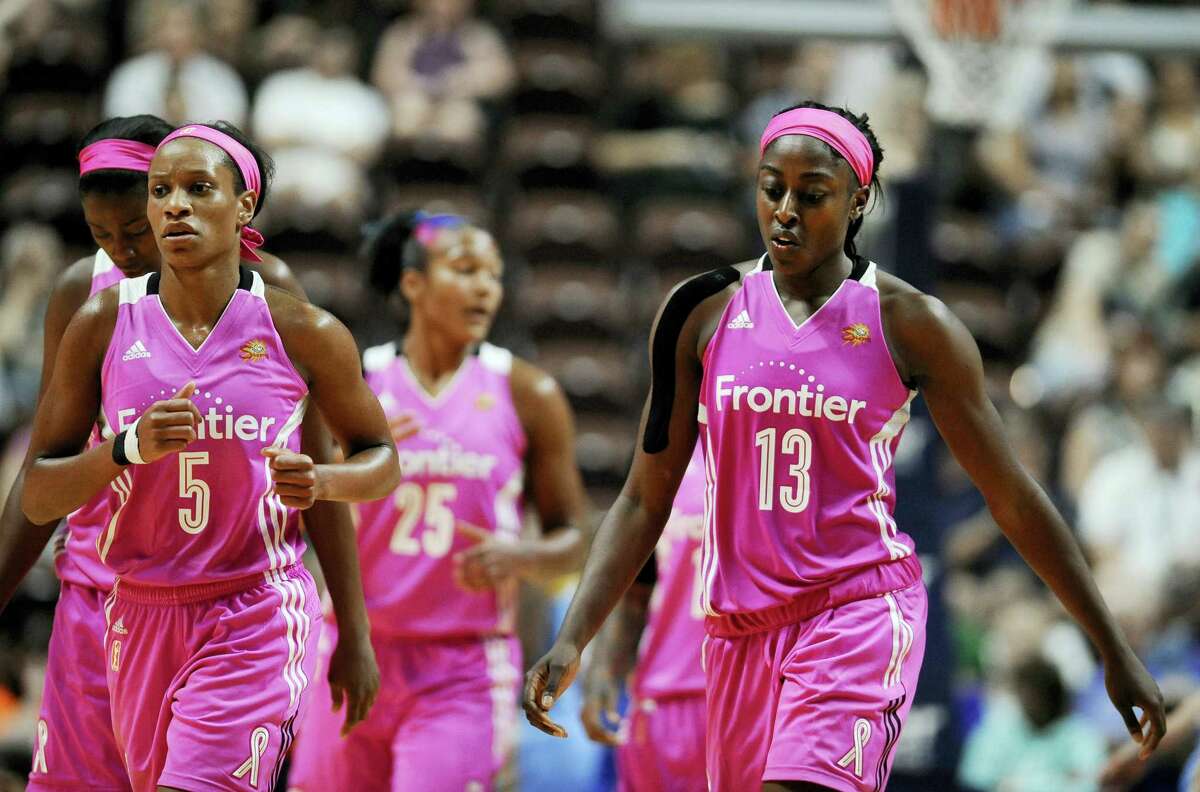 The Connecticut Sun’s Jasmine Thomas, left, and Chiney Ogwumike walk off the court during a timeout in the second half Sunday.