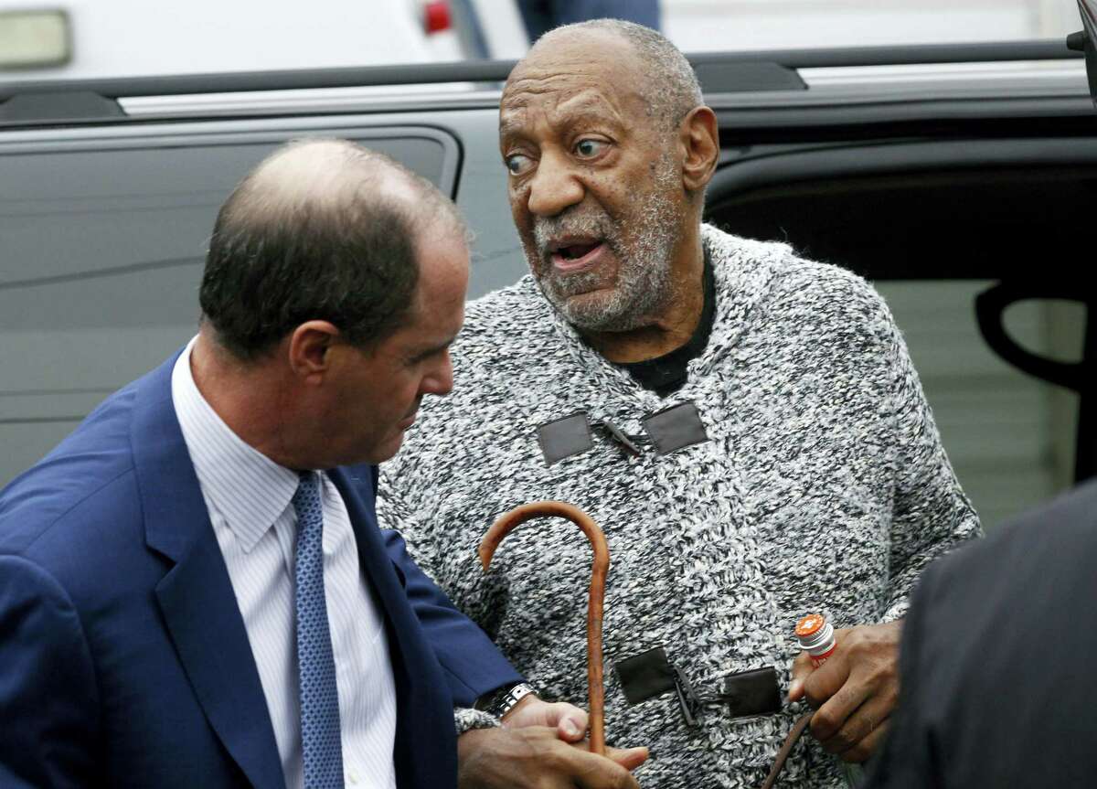 Comedian Bill Cosby is helped as he arrives for a court appearance in Elkins Park, Pa., Wednesday. Cosby was arrested and charged with drugging and sexually assaulting a woman at his home in January 2004.