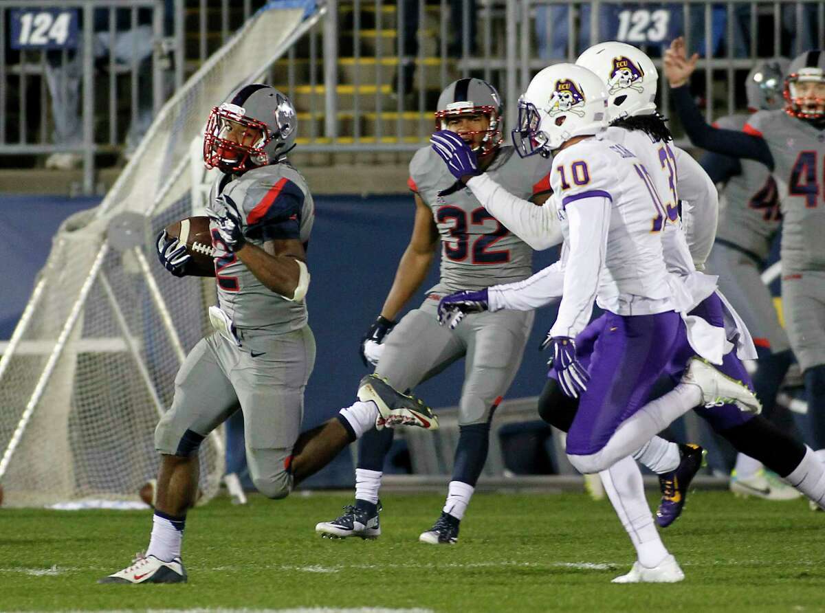 UConn running back Arkeel Newsome runs for a 90-yard touchdown as East Carolina’s Rocco Scarfone (10) and Domonique Lennon pursue during the third quarter of the Huskies’ 31-13 win on Friday in East Hartford.