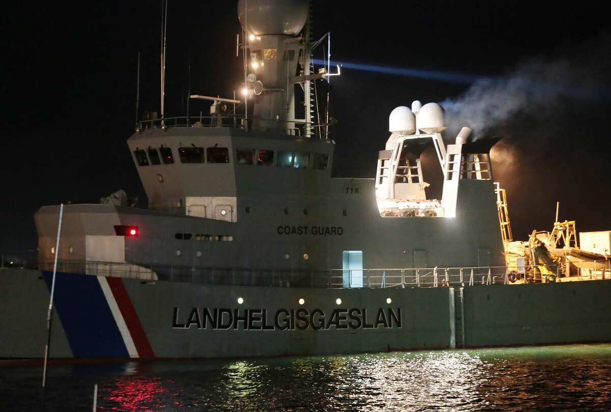 The Icelandic Coast Guard tows the cargo ship Ezadeen, carrying hundreds of migrants, as that arrives at the southern Italian port of Corigliano, Italy, Saturday, Jan. 3, 2015. The cargo ship was stopped with about 450 migrants aboard after smugglers sent it speeding toward the coast in rough seas with no one in command. Italian authorities lowered engineers and electricians onto the wave-tossed ship by helicopter to secure it, and the Icelandic Coast Guard towed it to the Italian port of Corigliano late Friday night. Smugglers who bring migrants to Europe by sea appear to have adopted a new, more dangerous tactic: cramming hundreds of them onto a large cargo ship, setting it on an automated course to crash into the coast, and then abandoning the helm. (AP Photo/Antonino D'Urso)