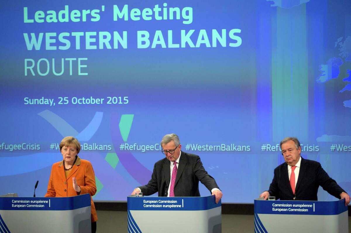 German Chancellor Angela Merkel, left, speaks during a media conference at the conclusion of an EU summit at EU headquarters in Brussels on Oct. 25. At center is European Commission President Jean-Claude Juncker and right is United Nation High Commissioner for Refugees Antonio Guterres.