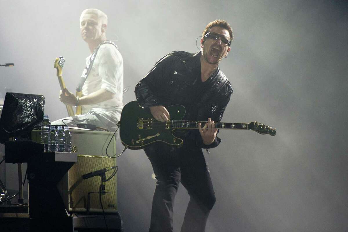 FILE - In this July 20, 2011 file photo, Bono, right, and Adam Clayton, from the rock group U2, perform in concert as part of U2ís 360 Tour at the New Meadowlands Stadium in East Rutherford, N.J. Bono wrote on the band's website Thursday Jan. 1, 2015, he may never play guitar again due to injuries suffered in a New York City cycling accident in November. (AP Photo/Charles Sykes, file)