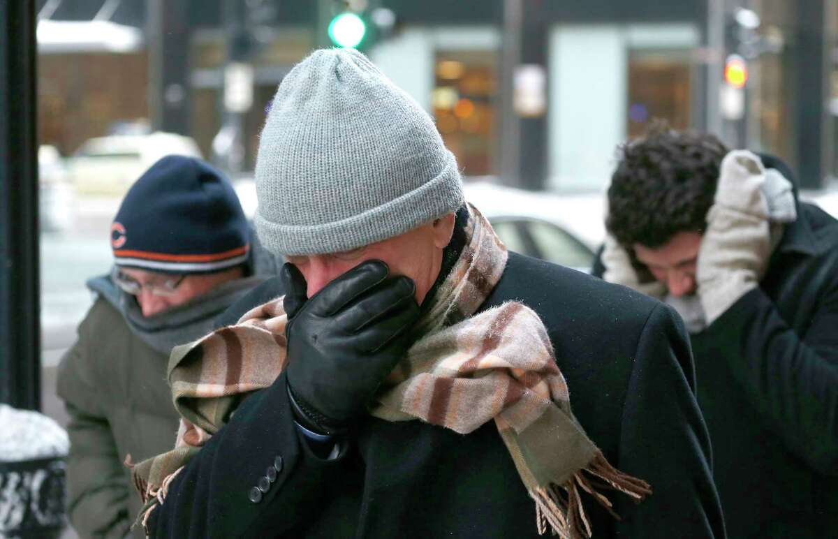 Three men protect themselves from the elements as they walk in Chicago’s Loop with temperatures well below zero and wind chills expected to reach 40 to 50 below last January.