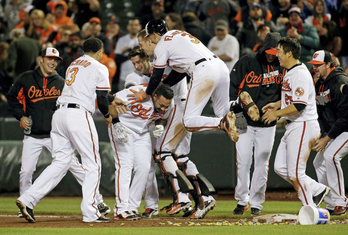 Members of the Baltimore Orioles celebrate with designated hitter Pedro Alvarez, third from left, after he hit a sacrifice fly ball in the 10th inning to defeat the Yankees 1-0