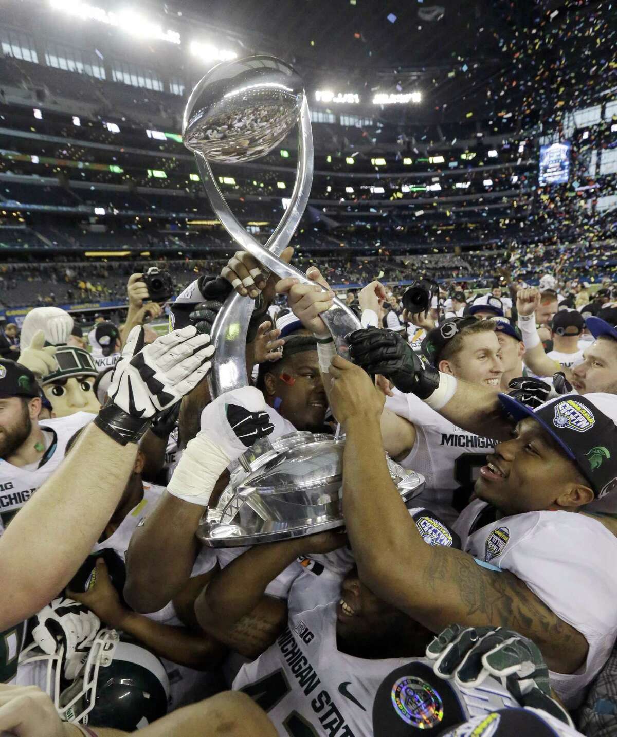 Michigan State players hoist the trophy after they beat Baylor 42-41 in the Cotton Bowl on Thursday in Arlington, Texas.