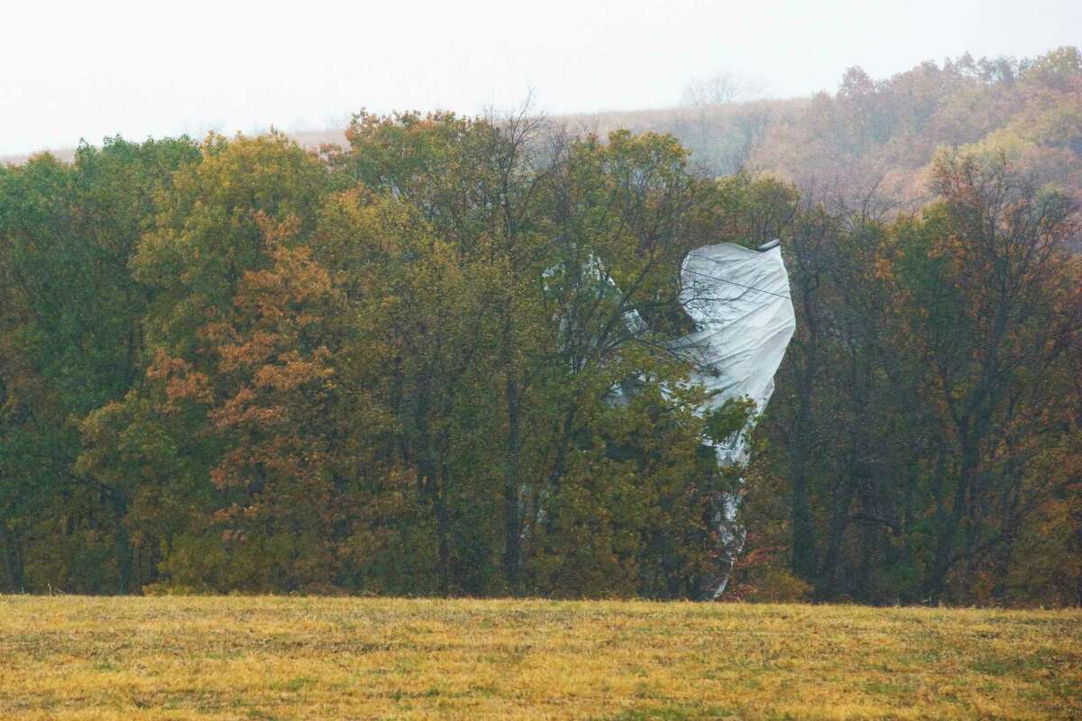 Part of what appears to be an unmanned Army surveillance blimp rests in the trees near Muncy, Pa., on Wednesday, Oct. 28, 2015. The 240-foot helium-filled unmanned Army surveillance blimp broke loose from its mooring in Maryland and floated over Pennsylvania for hours Wednesday with fighter jets on its tail, triggering blackouts across the countryside as it dragged its tether across power lines.