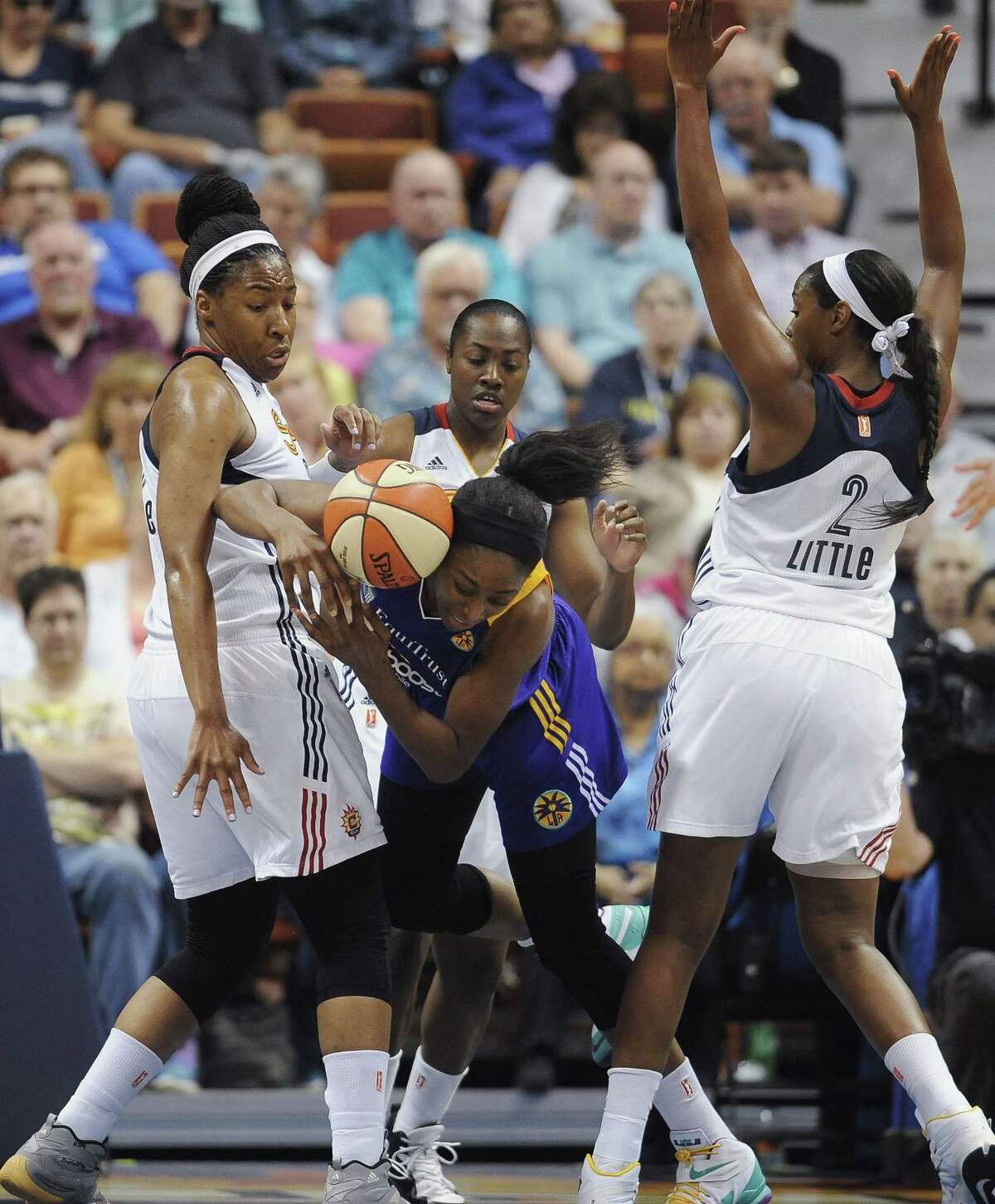The Los Angeles Sparks’ Nneka Ogwumike, center, stumbles under pressure from the Connecticut Sun’s Kelsey Bone, left, and Camille Little, right, during a recent game.