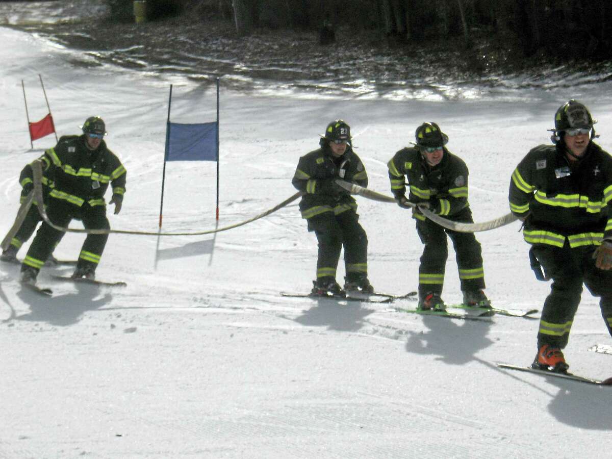 John Torsiello photo The Danbury Fire Department team crosses the finish line.