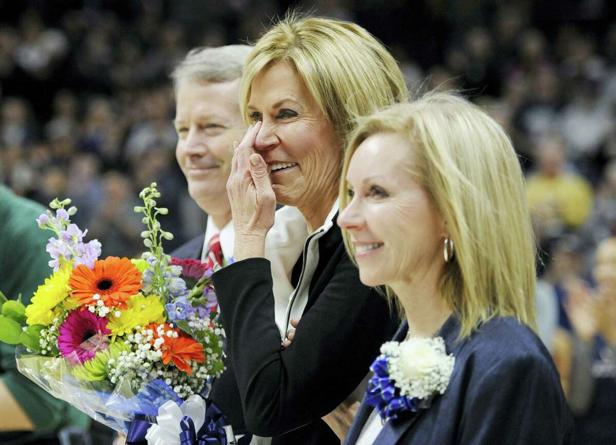 UConn associate head coach Chris Dailey wipes a tear away as she stands with her family during a surprise unveiling of her name on the UConn Huskies of Honor wall on Saturday.