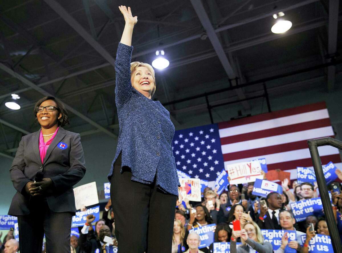 Democratic presidential candidate, Hillary Clinton, right, waves to the crowd as she takes the stage for a campaign event at Miles College as Jynae Jones, president of the student government association looks on Saturday, Feb. 27, 2016, in Fairfield, Ala.