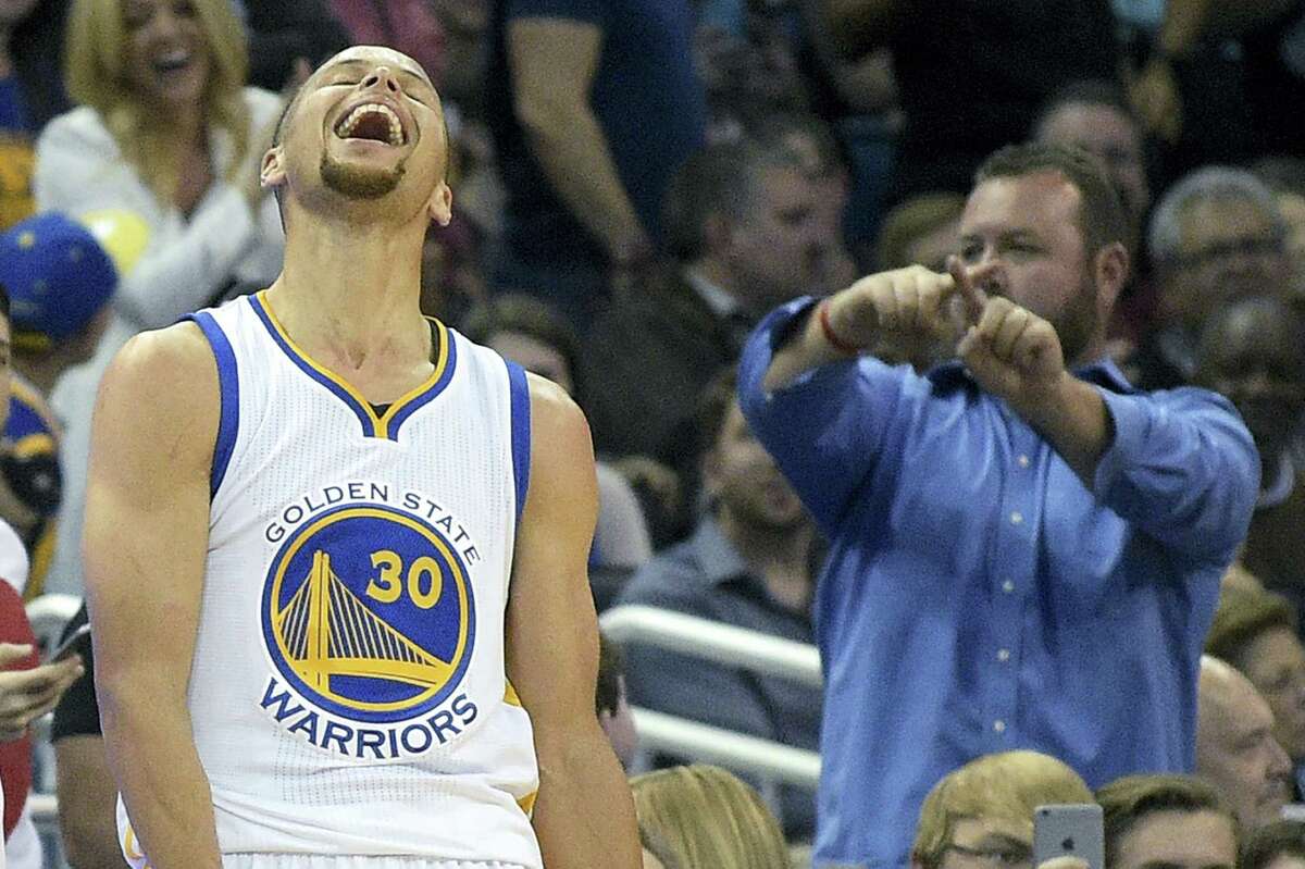 Warriors guard Stephen Curry (30) celebrates after making a 3-pointer from near the half-court line during a recent game.