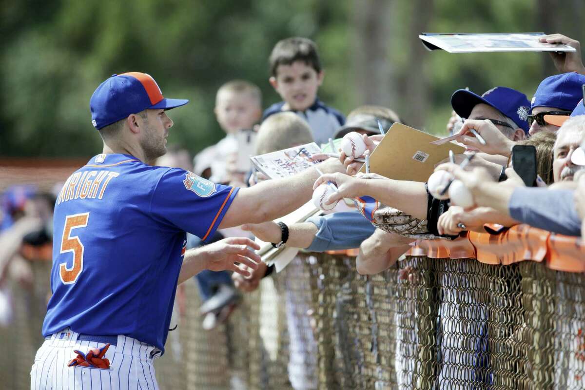 The Mets’ David Wright signs autographs during spring training on Friday in Port St. Lucie, Fla.