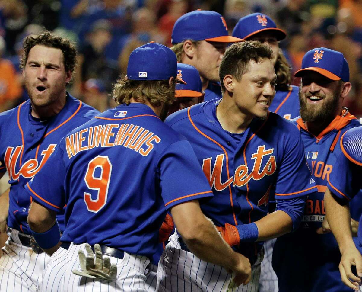 In this file photo from July 31, the Mets’ Wilmer Flores, center right, is mobbed by teammates after hitting a walk-off solo home run during the 12th inning to beat the Nationals just two days after Flores thought he had been traded.