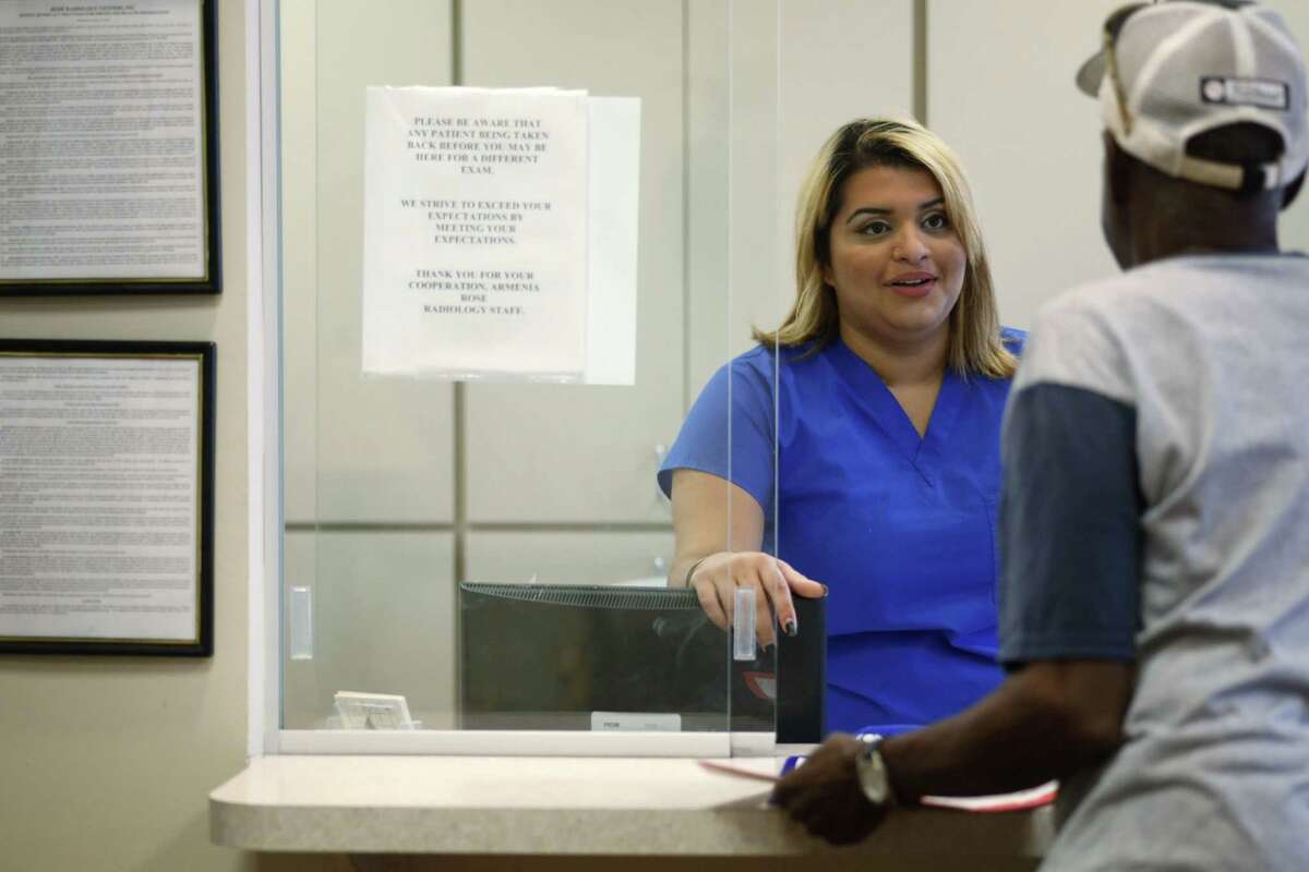 Lizzie Jimenez, 22, of Tampa, talks with a patient at Rose Radiology in Tampa, Fla., Thursday. Jimenez is a nursing student at St. Petersburg College and volunteered to help people sign up for the Affordable Care Act, and ended up getting herself coverage through the law. The Supreme Court sent a clear message Thursday that President Barack Obama’s health care overhaul is here to stay, rejecting a major challenge that would have imperiled the landmark law and health insurance for millions of Americans.