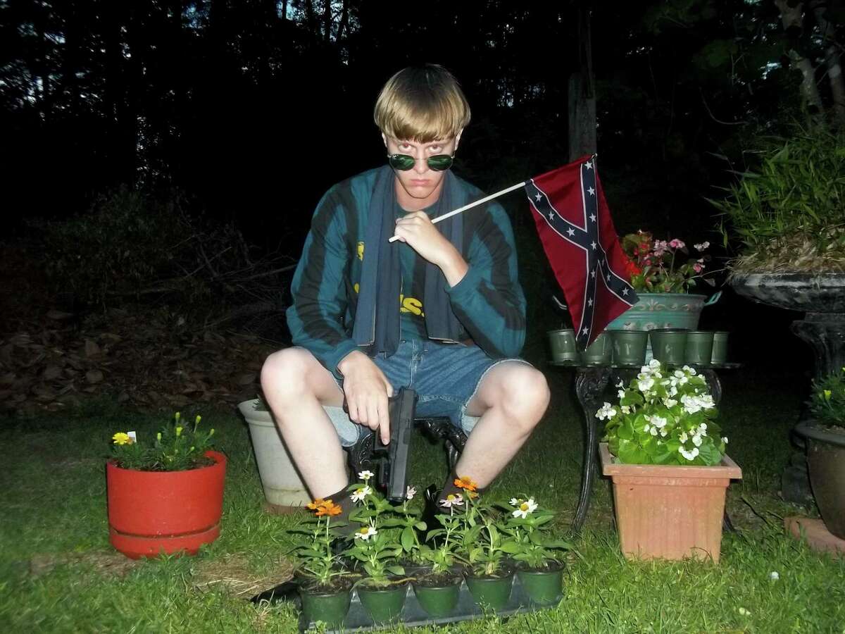 This undated file image that appeared on Lastrhodesian.com, a website being investigated by the FBI in connection with Charleston, S.C., shooting suspect Dylann Roof, shows Roof posing for a photo while holding a Confederate flag.