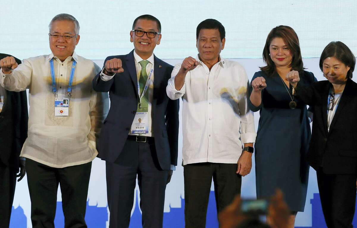 Philippine President Rodrigo Duterte, third from right, poses with a fist bump with business leaders following his address to ASEAN Business and Investment Summit, a parallel summit in the ongoing 28th and 29th ASEAN Summits and other related summits Tuesday, Sept. 6, 2016 in Vientiane, Laos.