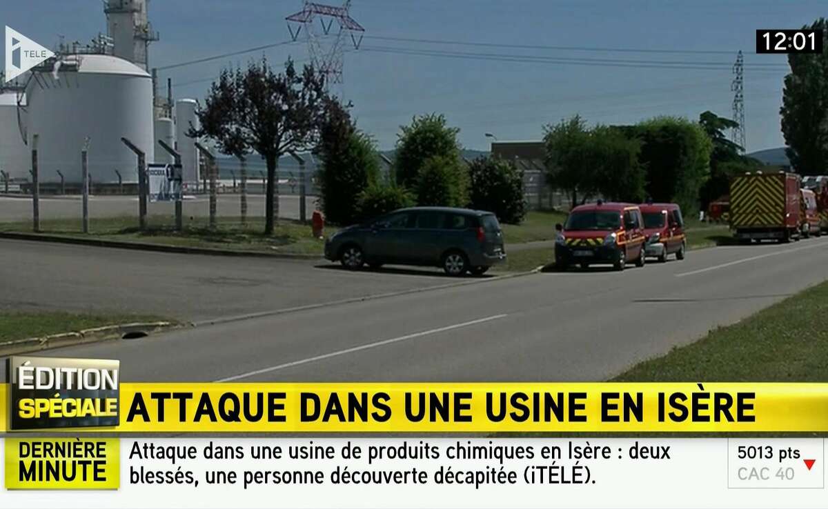 In this screen grab taken from video provided by I Tele, emergency services at the scene outside a factory where a man was allegedly beheaded, in Saint-Quentin-Fallavier, France, Friday, June 26, 2015. French authorities have opened an investigation after an attack and explosion at a gas factory that left one person decapitated and several wounded. Banners with Arabic inscriptions were found near the body, an official said. (I Tele via AP)