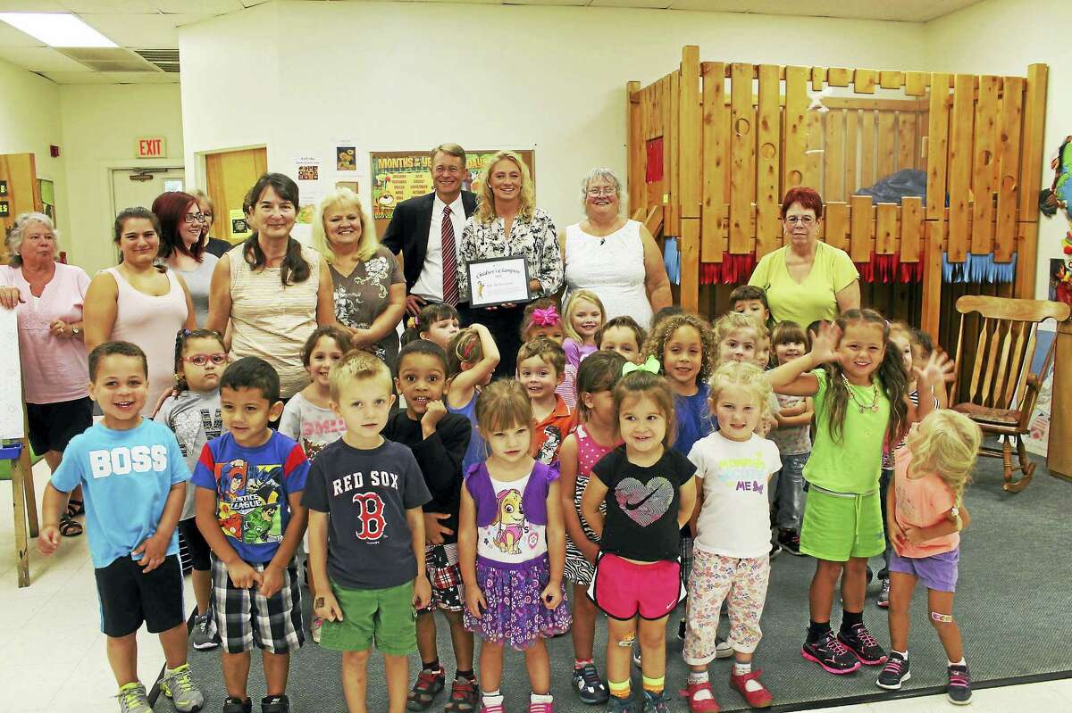 Photo courtesy of CT Early Childhood Alliance.Above, from left, are Rep. Michelle Cook, CT Early Childhood Alliance Executive Director Merrill Gay, Torrington Child Care Center Director Mary Cecchinato, staff and children.
