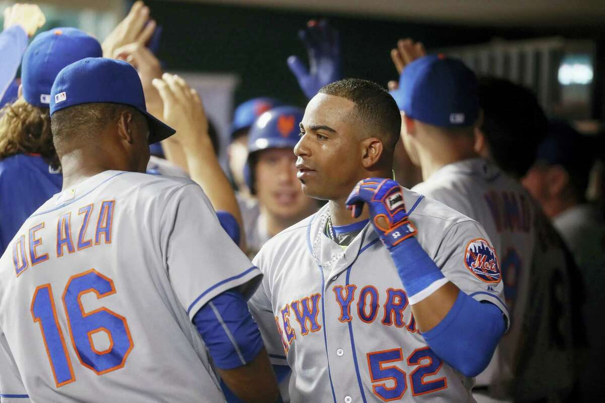 New York’s Yoenis Cespedes (52) celebrates in the dugout after hitting a two-run home run off Cincinnati Reds relief pitcher Michael Lorenzen during the seventh inning Tuesday. That blast helped the Mets beta the Reds for the 13th straight time.