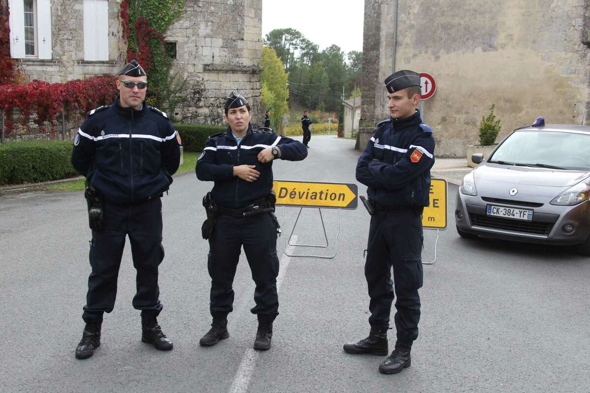 French gendarmes prevent access of a bus crash to the media in Puisseguin, near Bordeaux, southwestern France, following a road accident in which at least 42 people were killed, Friday, Oct. 23, 2015. A truck and a bus transporting retirees on a day trip collided and caught fire Friday on a country road in wine country in southwest France, killing 42 people and gravely injuring at least four others, authorities said.