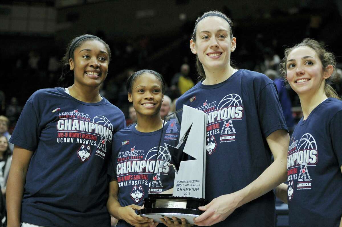 UConn seniors Morgan Tuck, Moriah Jefferson, Breanna Stewart and Briana Pulido, from left, pose with the regular season conference championship trophy at the end of the team’s win against SMU Wednesday.