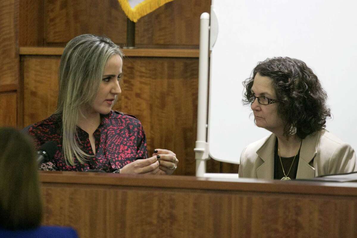 Grazielli Silva, left, communicates with an interpreter as she testifies during the murder trial for former NFL player Aaron Hernandez Monday.