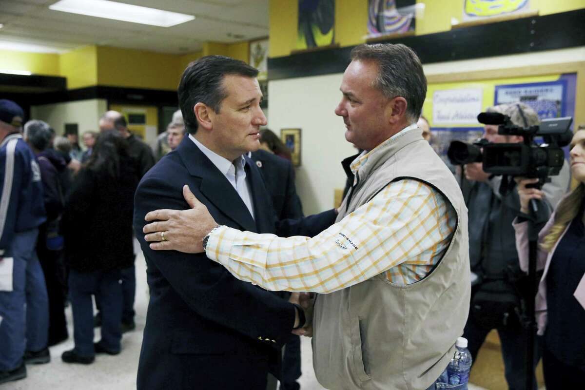 Republican presidential candidate, Sen. Ted Cruz, R-Texas, center left, talks with voter Greg Gerhardt while visiting a caucus location Tuesday, Feb. 23, 2016, in Reno, Nev.