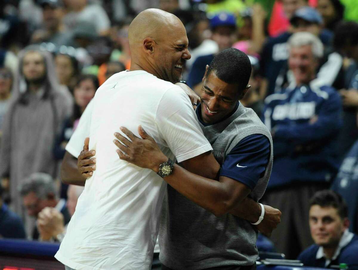 Former UConn star Donny Marshall, left, is embraced by head coach Kevin Ollie after Marshall won a 3-point shootout against Ray Allen at First Night on Friday in Storrs.