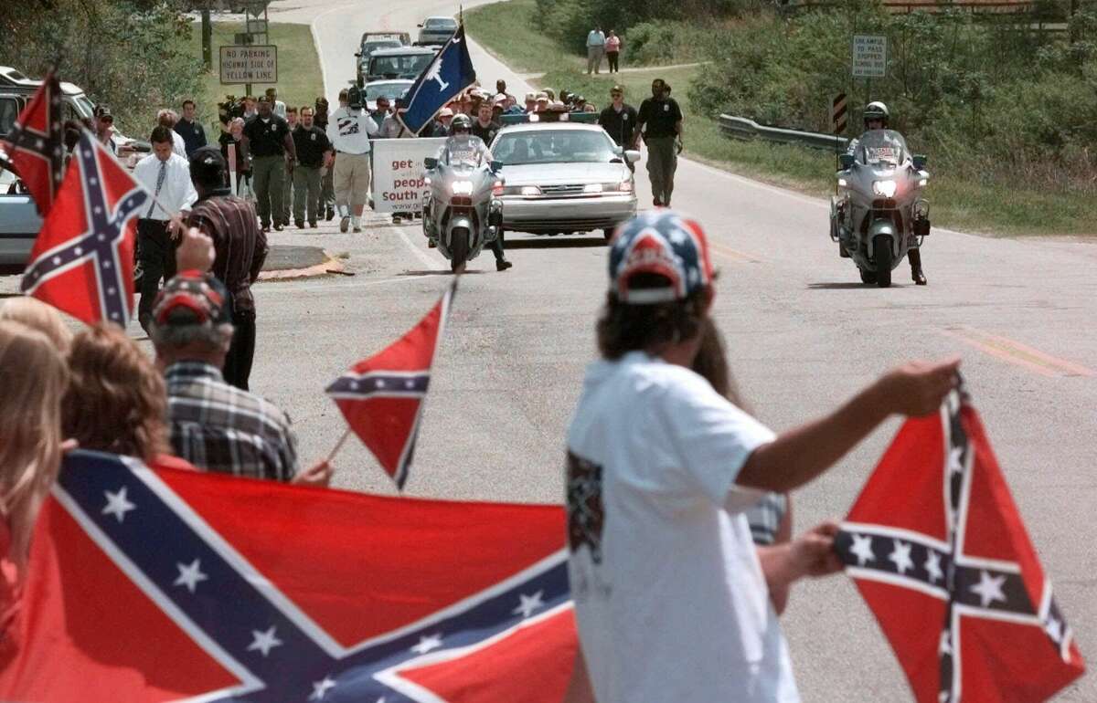 In this April 3, 2000 file photo, marchers make their way along Old State Road and are met by Confederate flag supporters near Moncks Corner, S.C.