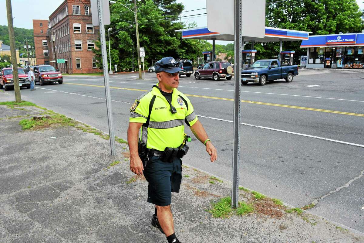Winchester police officer Daniel Pietrafesa walks through downtown Winsted while conducting a foot patrol.
