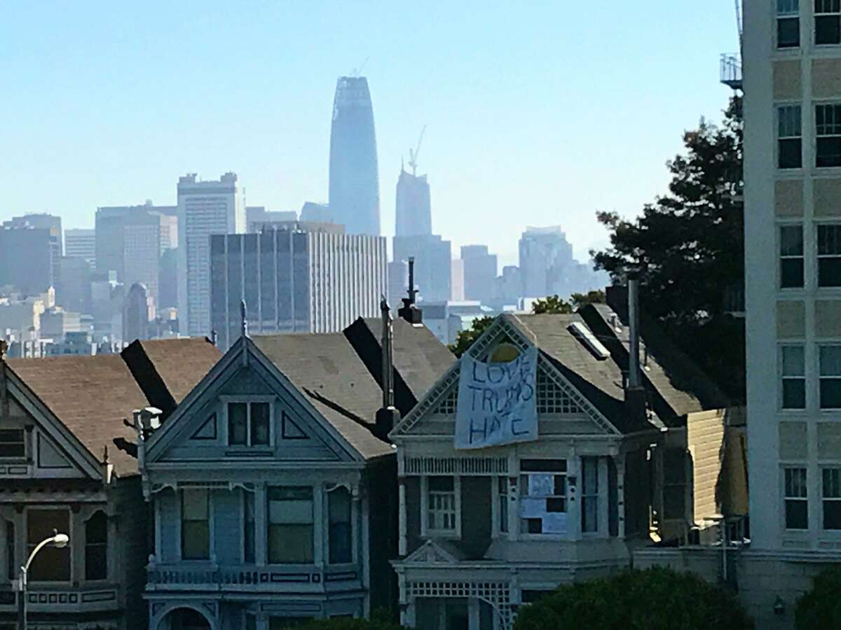 A banner hangs from one of the “Painted Ladies” across from Alamo Square Park in San Francisco.