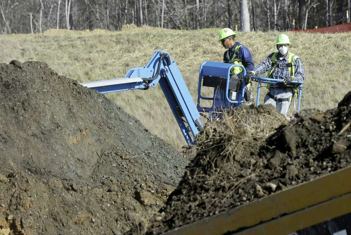 Workers excavate coal ash-laden soil to be removed from the Dan River Steam Station in Eden, N.C.