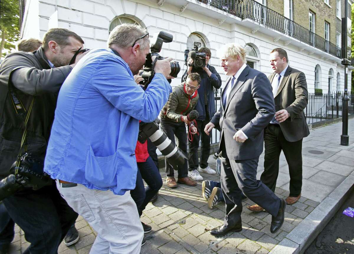 Former London mayor and prominent “Vote Leave” campaigner Boris Johnson, center, leaves his home in north London, surrounded by the media Tuesday.