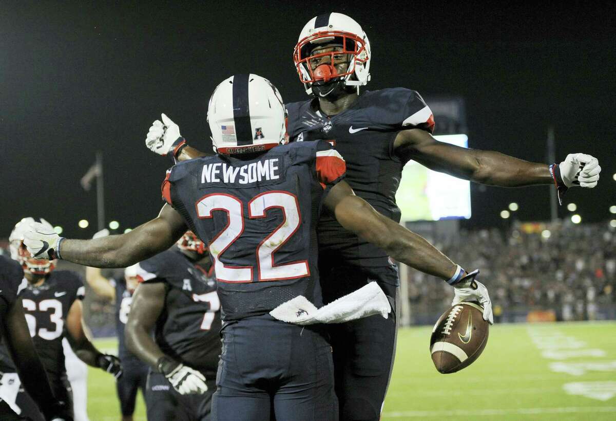 UConn’s Arkeel Newsome (22) and Hergy Mayala bump chests after Newsome scored a touchdown in the second half.