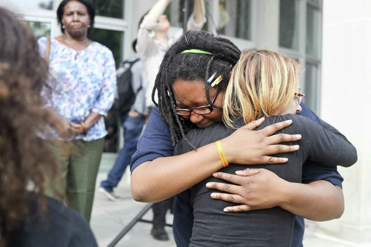 Jacquis Roberston, left, embraces her friend Laura Sprague moments after a vigil to mourn the lives lost at the shooting in Charleston, S.C., June 18, in Kalamazoo, Mich. Dylann Storm Roof, 21, was arrested Thursday in the slayings of several people, including the pastor at a prayer meeting inside a historic black church.